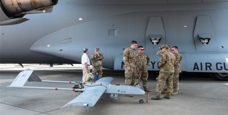 US soldiers stand next to a RQ7 Bravo Shadow Drone, under the wing of a C17 Globemaster III, during the Africa Aerospace and Defense Expo on September 20, 2018,