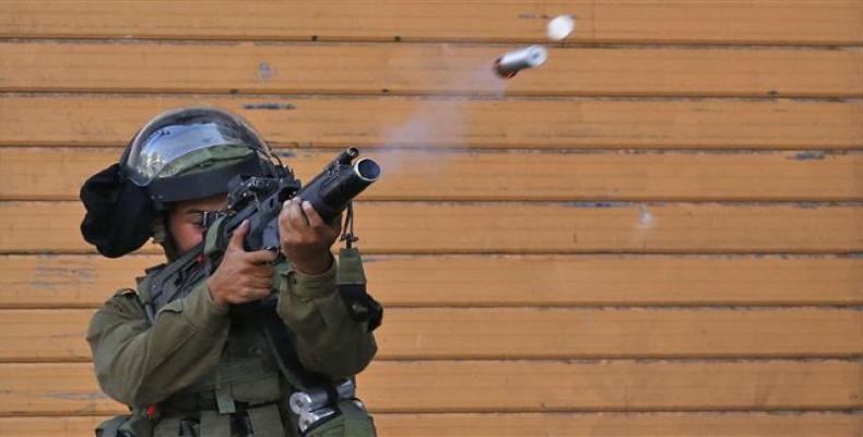 An Israeli soldier fires a tear gas canister during clashes with Palestinian protesters in the center of the occupied West Bank city of Hebron on July 13, 2018.