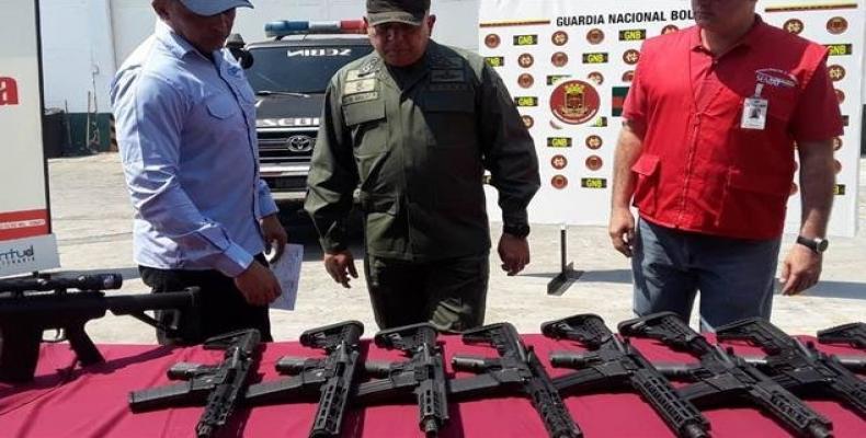Venezuelan authorities stand next to U.S.-made weapons seized from a cargo plane coming from Miami, Florida.  Photo: Ministry of Interior, Justice and Peace