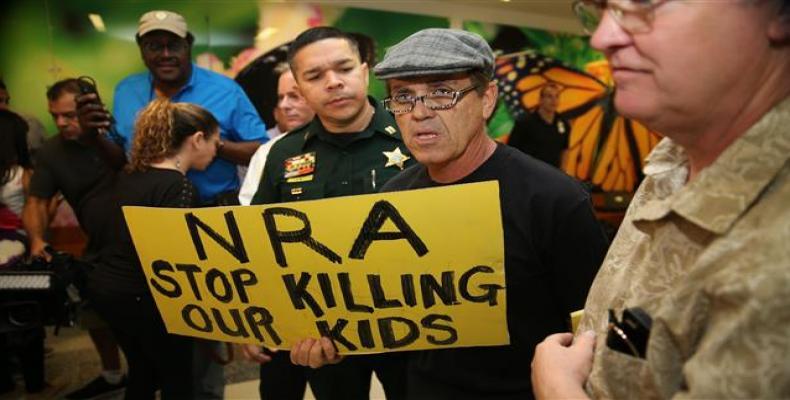 People protest against the National Rifle Association at the Broward County Court House during the first appearance in court via video link for high school shoo