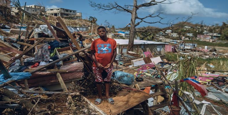 A man stands for a portrait in his neighborhood torn apart by Hurricane Maria, September 2017. (Photo: Time)
