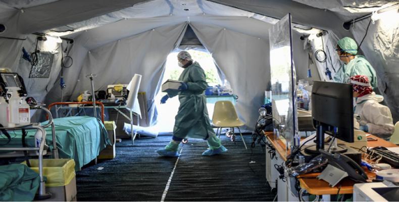 Medical personnel work inside one of the emergency structures that were set up to ease procedures outside the hospital of Brescia, Northern Italy, Tuesday, 10 M