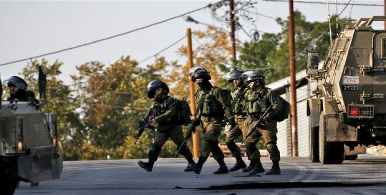 Israeli forces gather in a suburb of Tulkarm in the north of the occupied West Bank, after troops partially destroyed the house of a Palestinian accused of kill