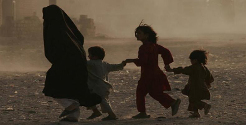 A family struggles through a dusty environment in Afghanistan. UNAMA / Fraidoon Poya