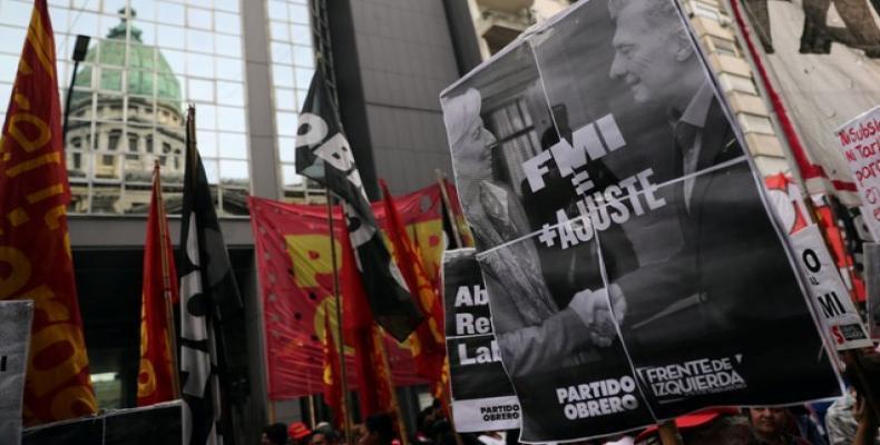 An activist of Workers Party holds a sign with a photo of International Monetary Fund (IMF) Managing Director Christine Lagarde and Argentine President Mauricio