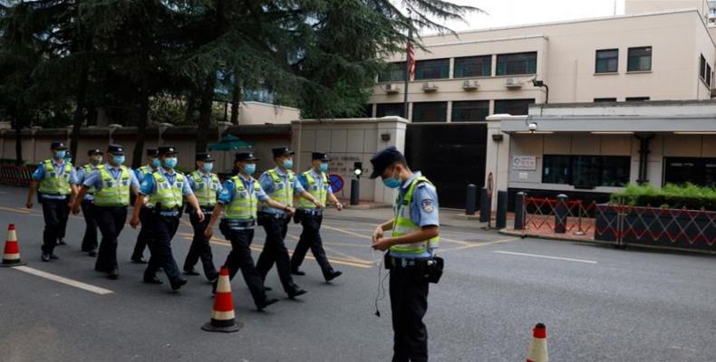 Chinese police march past U.S. consulate in Chengdu after it was ordered closed. (Photo: Ng Han Guan/AP)