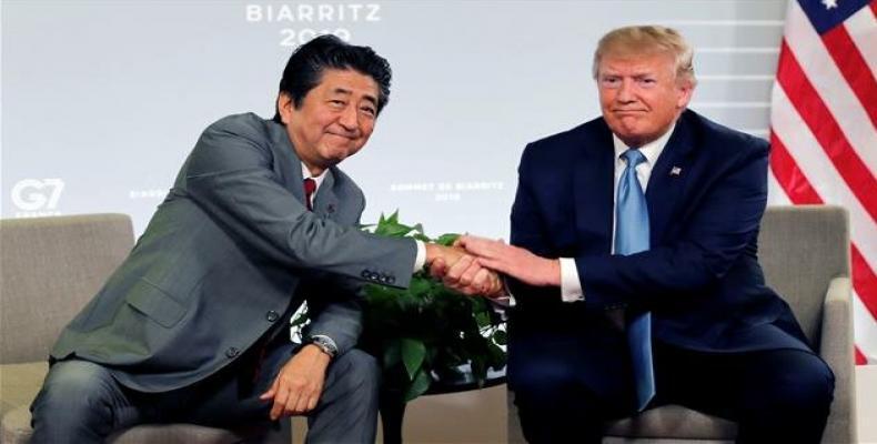 US President Donald Trump shakes hands with Japan's Prime Minister Shinzo Abe during a bilateral meeting in Biarritz, France on August 25, 2019. (Photo by Reute