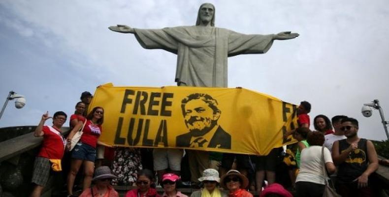 Supporters of former Brazilian President Luiz Inacio Lula da Silva display a banner in front of the statue of Christ the Redeemer in Rio de Janeiro, Brazil.  Ph