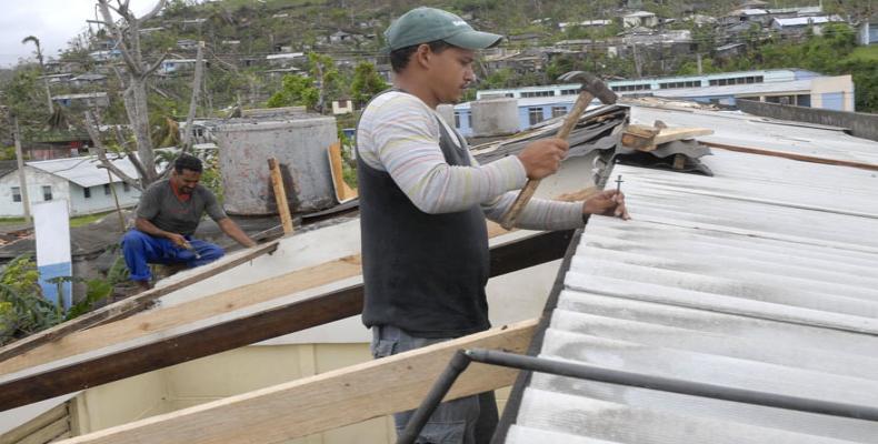 Trabajadores colocan techos a viviendas.  Foto: ACN
