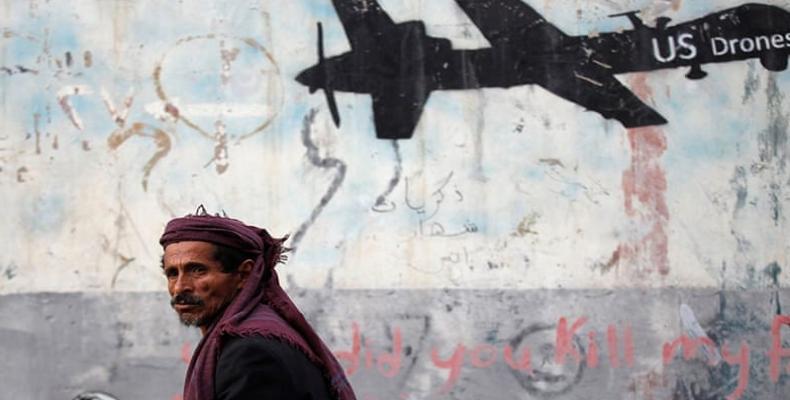 A man walks past graffiti that denounces strikes by US drones in Yemen, painted on a wall in Sanaa.  (Photo: Khaled Abdullah/Reuters)
