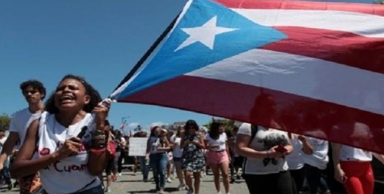 Students of the University of Puerto Rico wave the flag of their Island during a protest.  Photo: Reuters