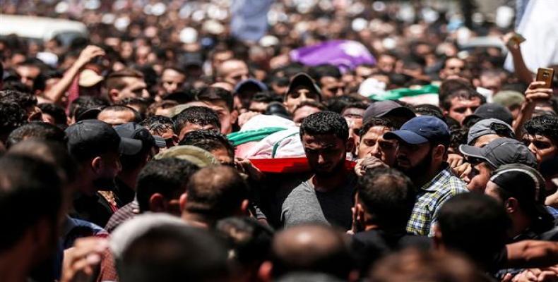 Palestinian mourners carry the body of a Hamas member killed by Israeli fire, during his funeral in Jabalia, in the northern Gaza Strip, on August 7, 2018.  Pho