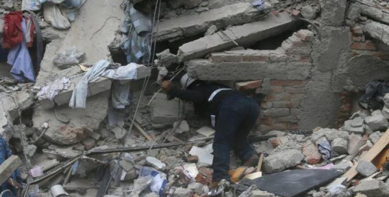 Un trabajador busca víctimas entre los escombros de un edificio derrumbado tras el terremoto. Foto: Eduardo Verdugo / AP