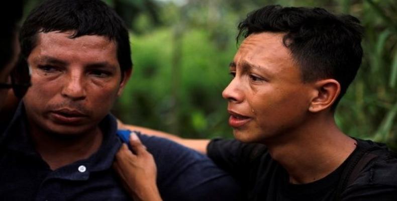 A migrant from El Salvador traveling to the U.S., cries during a Mexican police operation detaining them for entering the country illegally, Mexico, Nov. 21, 20