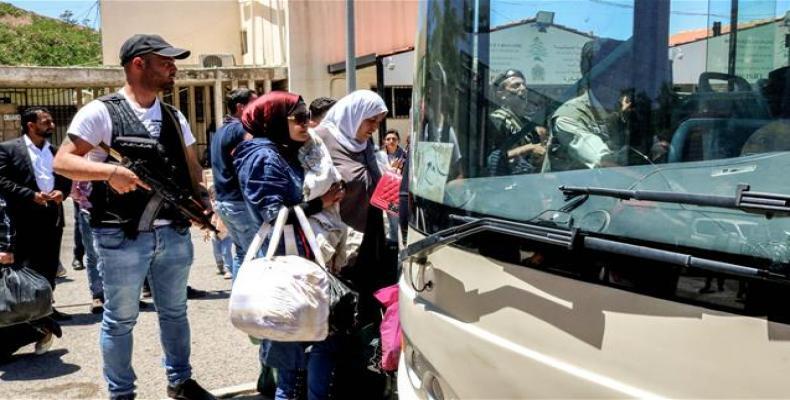 Syrian refugees board a bus evacuating them from Lebanon at the Masnaa crossing on the Lebanon-Syria border on July 1, 2018.  Photo: AFP