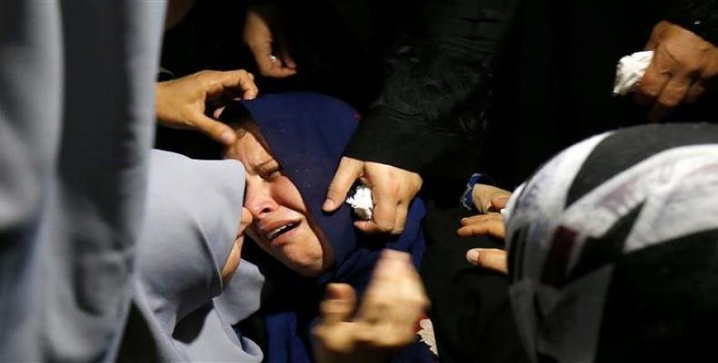 A Palestinian relative mourns over the death of Muadh al-Suri, aged 15, who was killed during clashes with Israeli forces the day before, during his funeral.  P