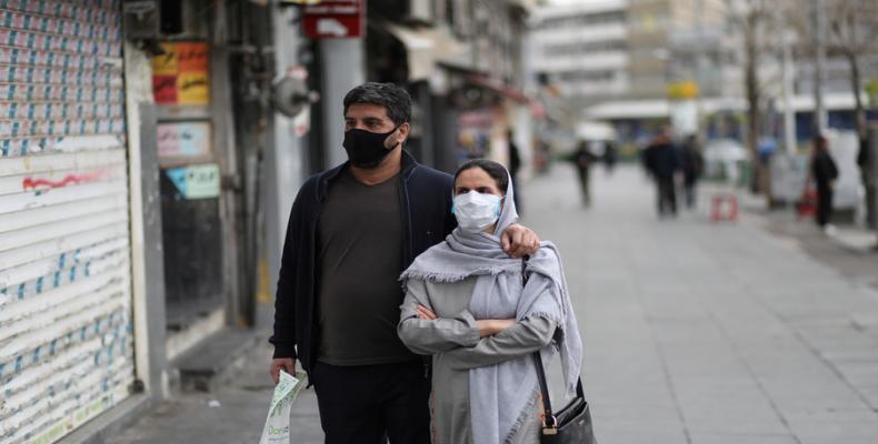 A couple wear protective face masks as they walk in Tehran. (Photo: © West Asia News Agency / Ali Khara via REUTERS)