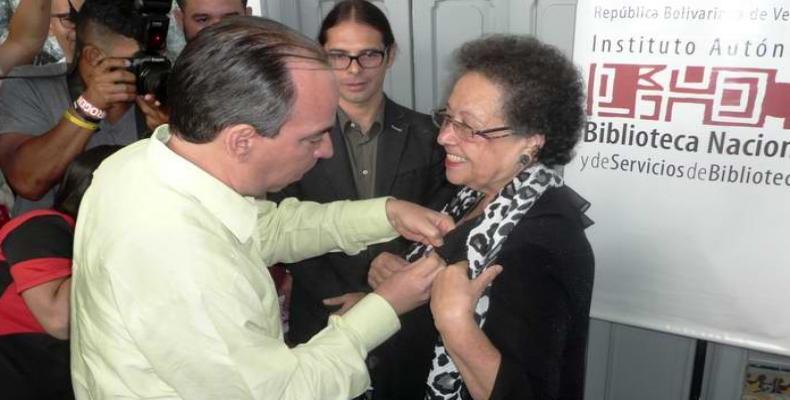 Rogelio Polanco, embajador de Cuba en Caracas condecora a María León. Foto: Minoska Cadalso/Enviada de la Radio Cubana a Venezuela