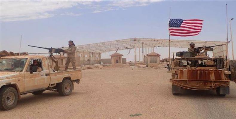 In this file picture, a US-backed Takfiri militant with a heavy automatic machinegun next to an American soldier as they take their positions at the al-Tanf bor