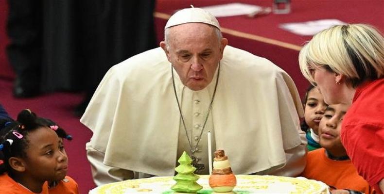 Pope Francis blows the candle of cake for his 82nd birthday, offered to him during an audience for children and families of the Santa Marta dispensary on Decemb