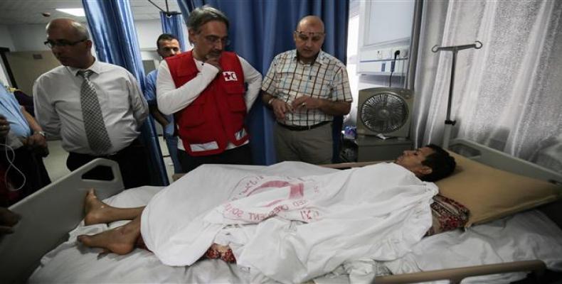 Francesco Rocca, the President of the International Federation of Red Cross and Red Crescent Societies, meets a Palestinian, receiving treatment for wounds sust