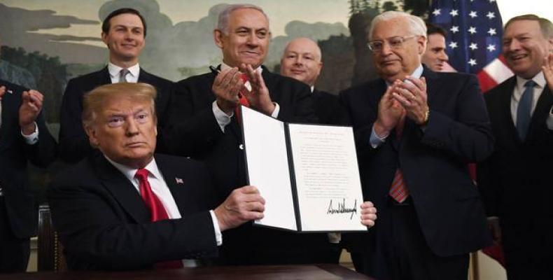 President Donald Trump holds up a signed proclamation recognising Israel's sovereignty over the Golan Heights