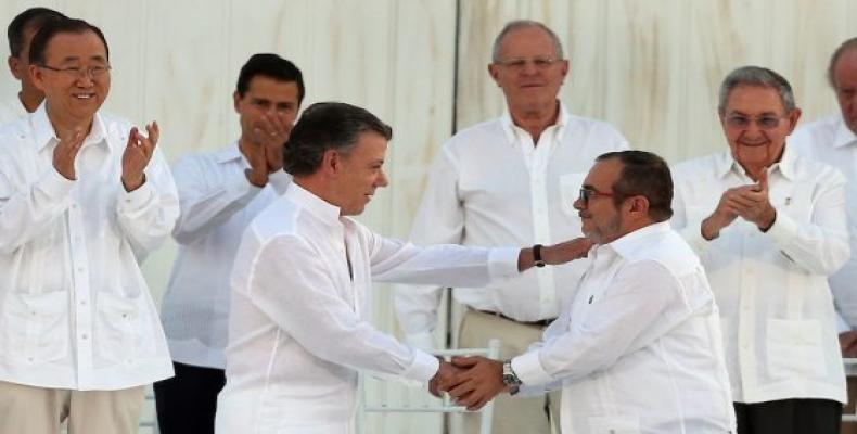 Santos y líder de las Farc-Ep se saludan tras firma acuerdo de paz. Foto:  AP