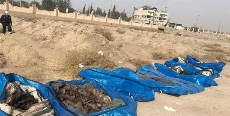 The remains of bodies recovered from a mass grave in the northwestern Syrian city of Raqqah.   Photo: RT Arabic television news network