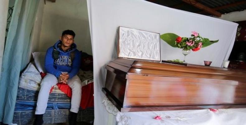 A relative cries near the coffins of Eddy Cabrera, 18, and William Mendoza, 18, 2 of 5 people shot dead January 10th during their wake in Tegucigalpa, Honduras,