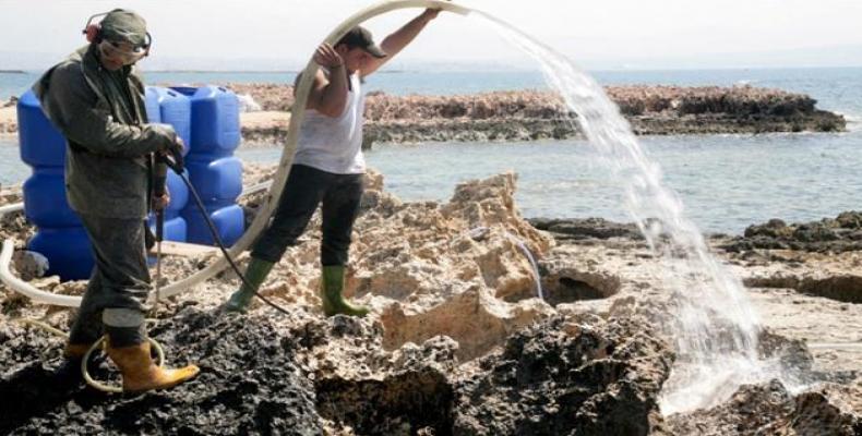 Lebanese workers clean up an oil spill near the city of Tripoli in 2009.  (Photo: AFP)