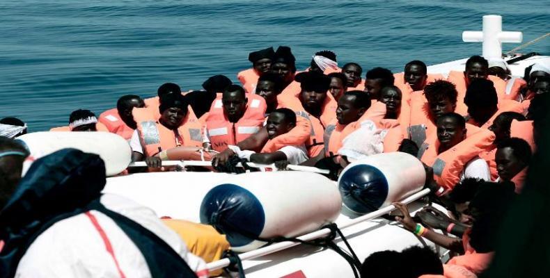 Men wait to disembark from the Italian Coast Guard vessel &quot;Diciotti&quot; following a rescue operation of refugees at sea on June 13, 2018, in the port of