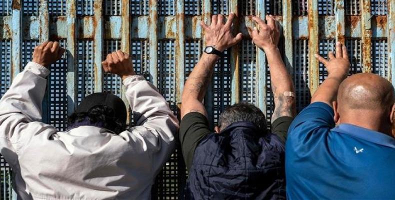 People lean against the US-Mexico border fence in Playas de Tijuana, Baja California state, Mexico on February 3, 2019.  Photo: AFP