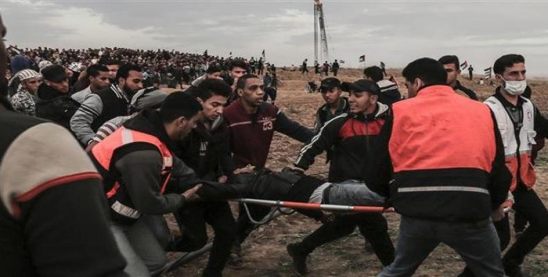 Palestinian men carry an injured man during a protest on November 16, 2018, on the eastern outskirts of Gaza City.  Photo: AFP