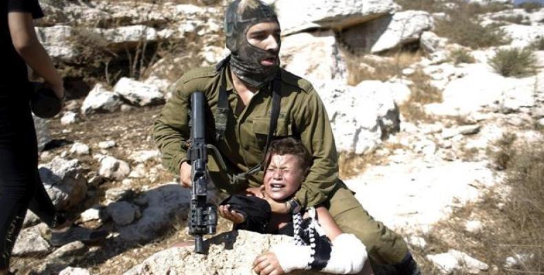 An Israeli soldier detaining a 12-year-old Palestinian boy in the West Bank.   Photo: File