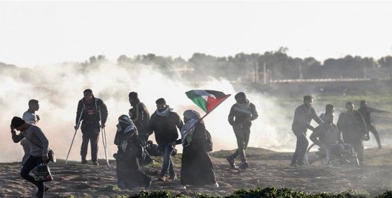 Palestinian protesters run away from teargas canisters during clashes with Israeli forces following a demonstration along the Gaza border east of Gaza City on J