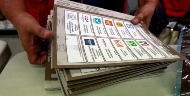 An employee of the National Electoral Institute (INE) arranges voting materials for the upcoming July 1 presidential elections, in Ciudad Juarez, Mexico.   Phot