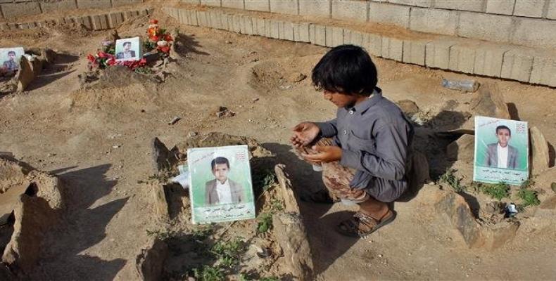 Yemeni child by the graves of schoolboys killed while on a bus that was hit by a Saudi airstrike.  Photo: AFP