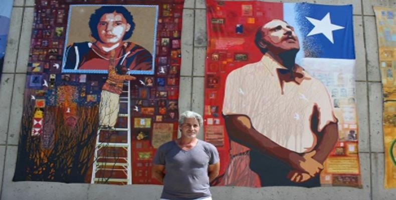 Fotografía de Francisco Letelier, hijo de Orlando Letelier, posando junto al mural que pintó sobre su padre, en el Museo de la American University en Washington