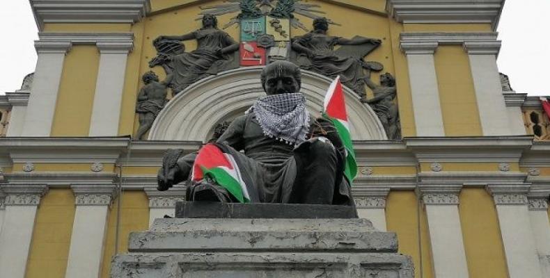 Student protesters against Israeli killings of Gaza protesters place Palestinian flag and scarf on a statute at their university Universidad de Chile in Santiag