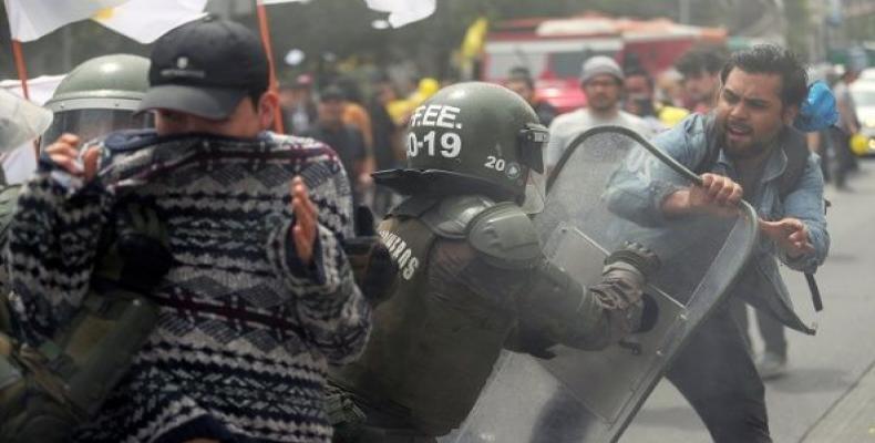 A demonstrator clashes with a riot policeman during a rally against Chilean pension fund administrators, in Santiago, Chile.  Photo: teleSUR