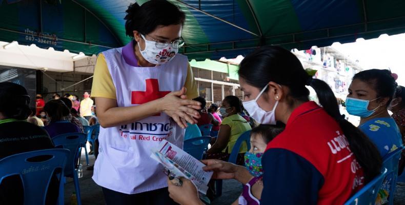 A Red Cross worker in Thailand hands out COVID-19 information at an event for migrant workers.  (Photo: Thai Red Cross)