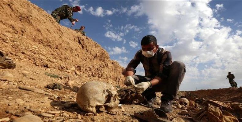 An Iraqi man inspects a mass grave near the town of Sinjar, situated over 400 kilometers northwest of the capital Baghdad.  Photo: AFP