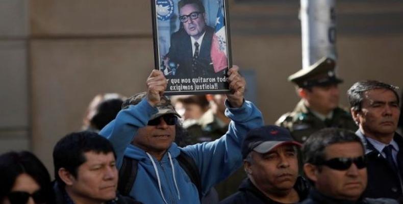 Worker holds a picture of Salvador Allende at a rally.  (Photo: Reuters)
