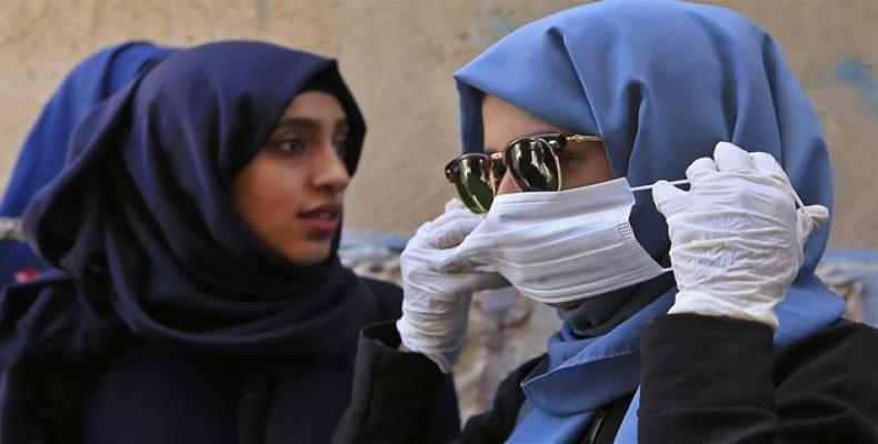 Yemeni woman puts on a protective face mask as she walks in a street in the Yemeni capital, Sanaa.  (Photo: AFP)