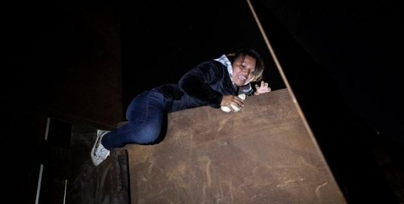 An asylum seeker, part of a caravan of thousands from Central America jumping a border fence from Mexico to the U.S, in Tijuana, Mexico, Dec. 3, 2018   Photo: R