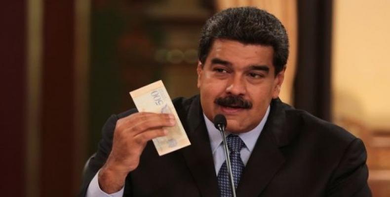 Venezuela's President Nicolas Maduro holds a bank note from the new Venezuelan currency Sovereign Bolivar at Miraflores Palace in Caracas, Venezuela.  Photo: Re
