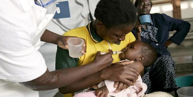 Una enfermera le administra agua con azúcar a un niño enfermo de cólera de Zimbabue. Foto/ABC.es