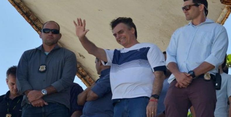 Brazil's new president-elect, Jair Bolsonaro, waves to supporters as he watches airplanes performing near his condominium at Barra da Tijuca neighbourhood in Ri