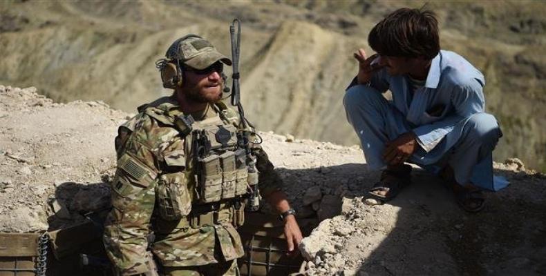 A U.S. Army soldier from NATO and a member of Afghan Local Police (ALP) look on in a checkpoint during a patrol against Daesh Takfiri terrorists at Deh Bala dis