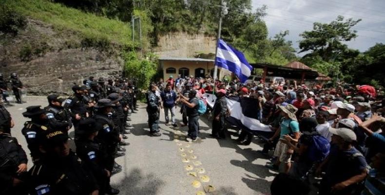 Guatemala's police officers stand as Honduran migrants, part of a caravan trying to reach the U.S., arrive at the border between Honduras and Guatemala.  Photo: